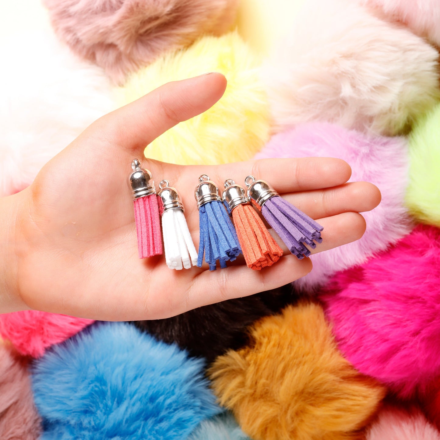 Image of Keychains and Pom Poms in Hand from the Bulk Pom Poms Keychains Set | Caption-Keychains and Pom Poms in Hand from the Bulk Pom Poms Keychains Set