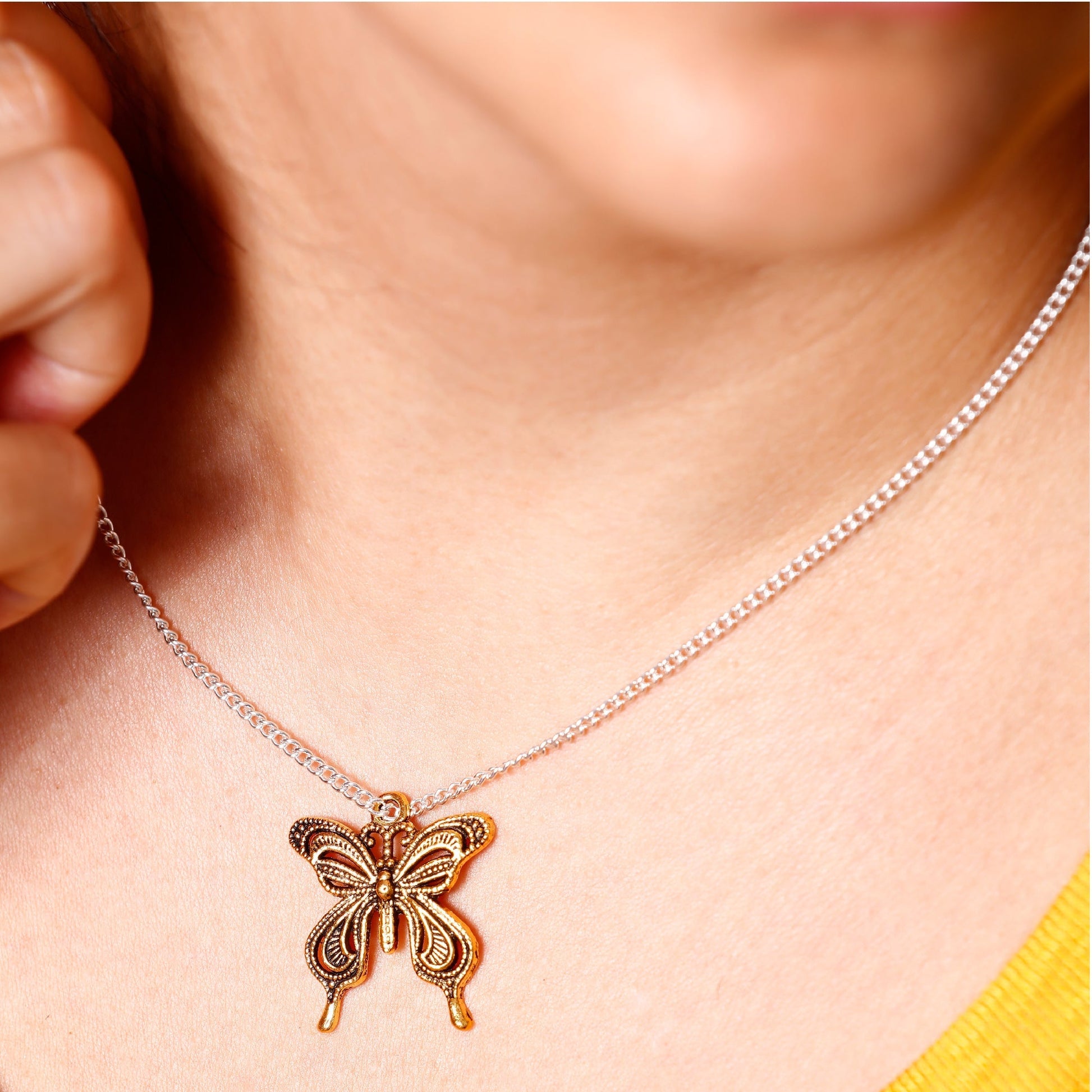 Image of Woman Wearing a Necklace with a Butterfly Charm from the Bulk Gold Charms Set | Caption-Woman Wearing a Necklace with a Butterfly Charm from the Bulk Gold Charms Set